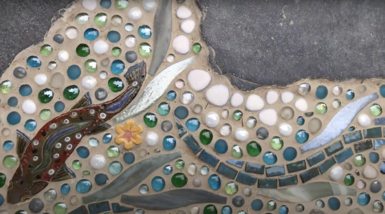 close up of mosaic stream with fish and flower